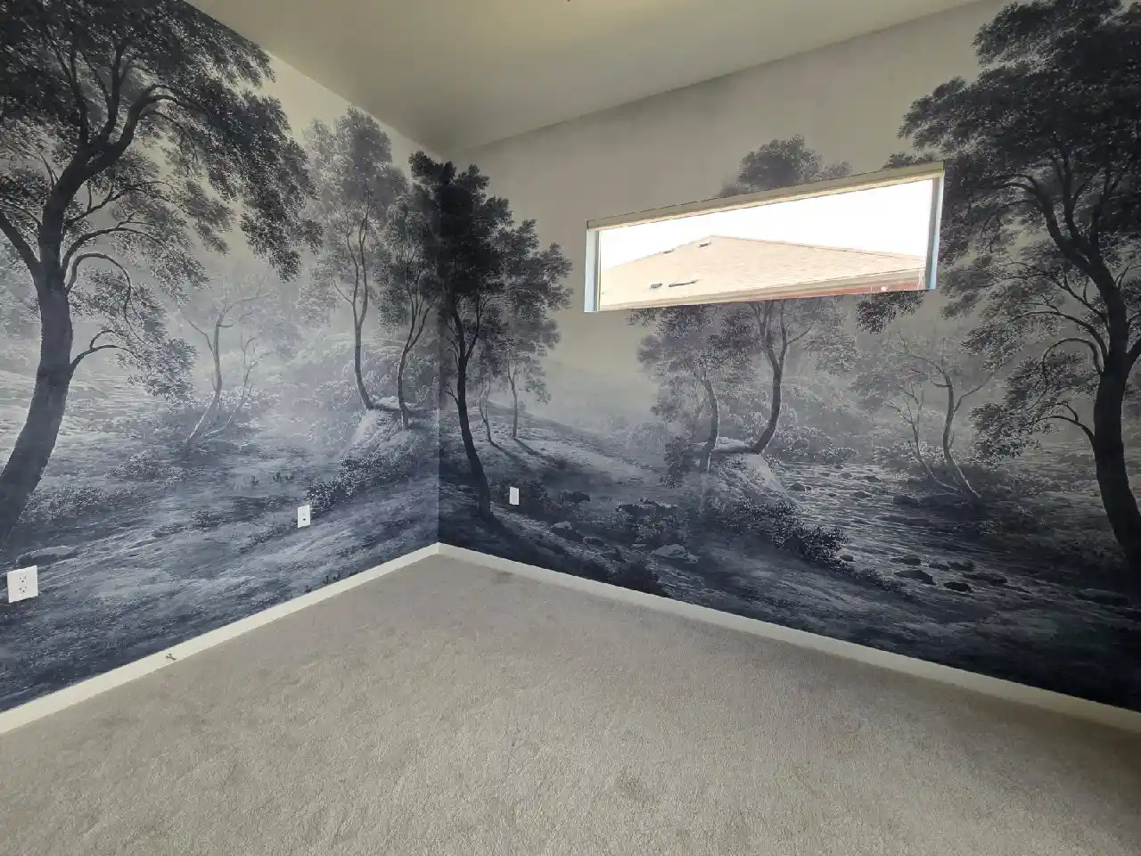 Empty room wrapped in a charcoal-gray forest landscape wall mural with a narrow horizontal window.